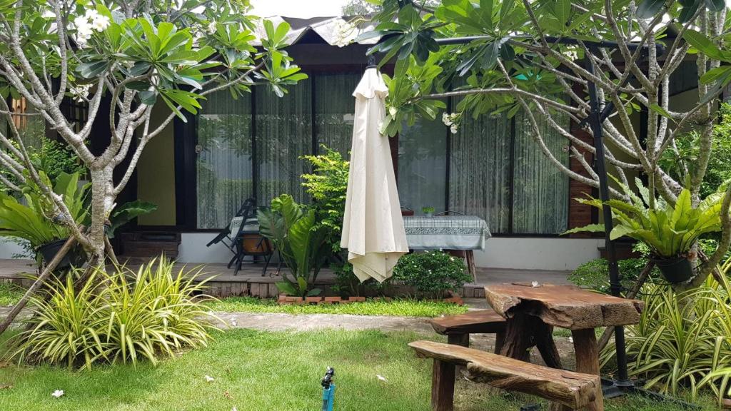 a patio with an umbrella and a table and a bench at The Park Ayutthaya Resort And Spa in Phra Nakhon Si Ayutthaya