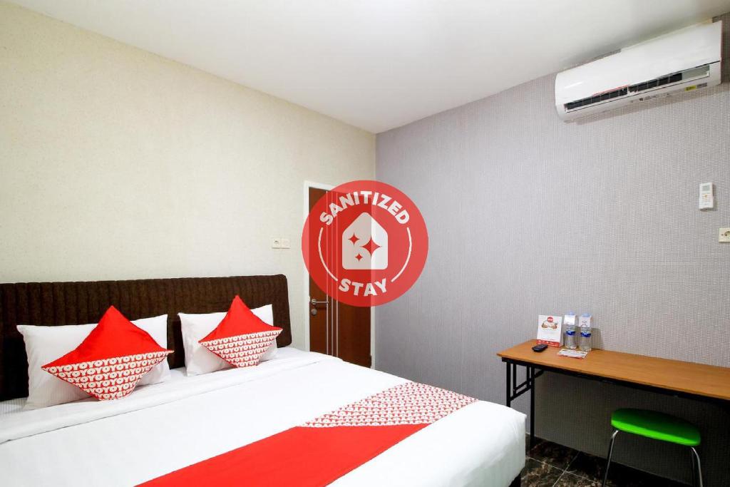 - une chambre avec un lit doté d'oreillers rouges et blancs dans l'établissement Super OYO Capital O 217 A1 Hotel, à Surabaya