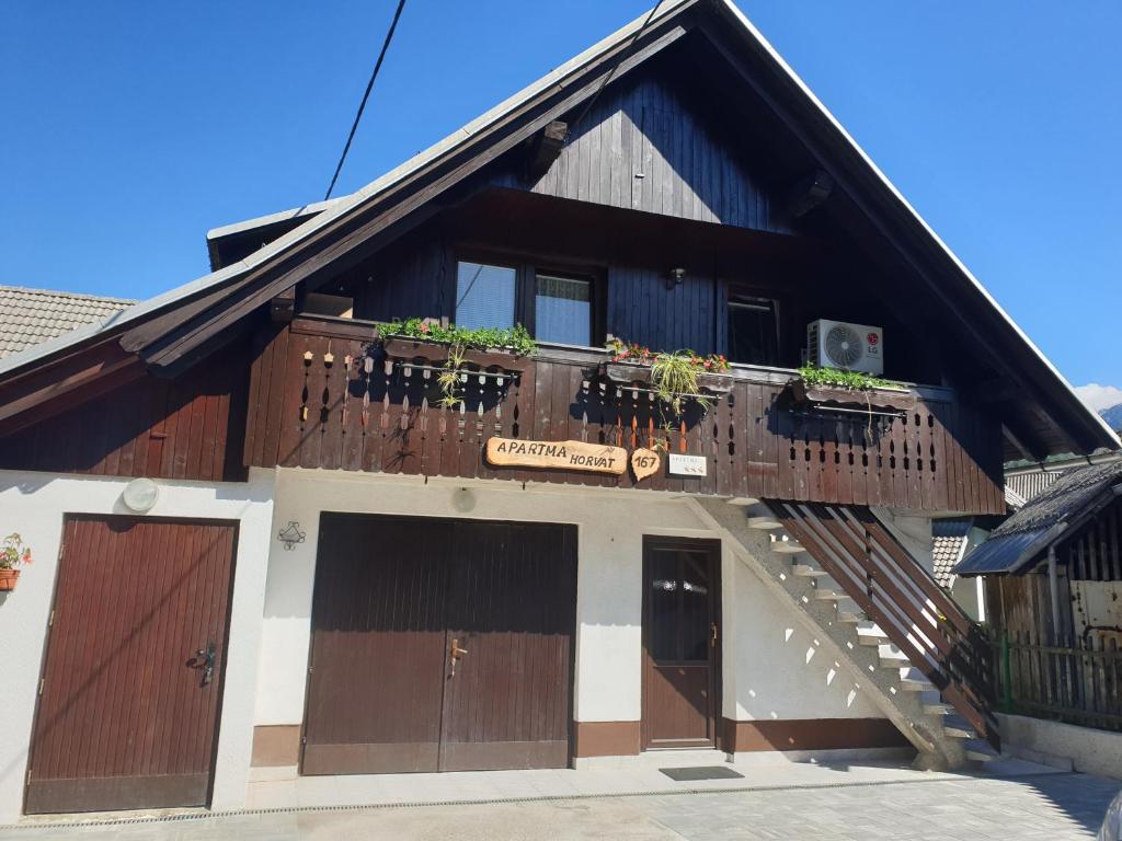 a building with a balcony with plants on it at Apartma Horvat in Bohinj