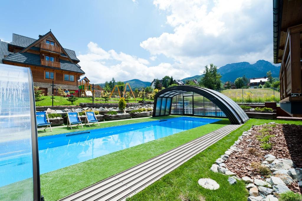 扎科帕內的住宿－Apartamenty Sun & Snow Resorts Lipki Park z sauną，一座游泳池,一座庭院上方的桥梁