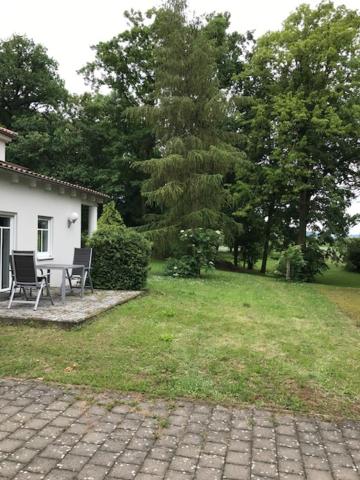 d'une terrasse avec 2 chaises et une table dans la cour. dans l'établissement Friedensoase, à Ebensfeld