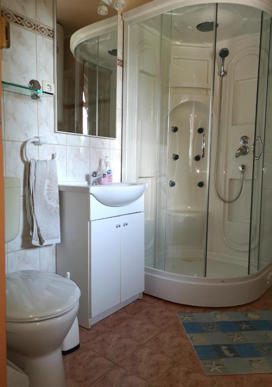 łazienka z prysznicem, toaletą i umywalką w obiekcie Vitorlás Apartmanház w Siófoku