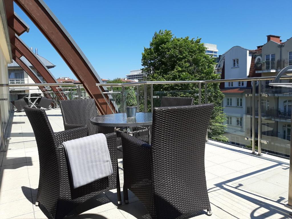 patio con mesa y sillas en el balcón en Apartament LAPIS Panorama Avangard en Świnoujście