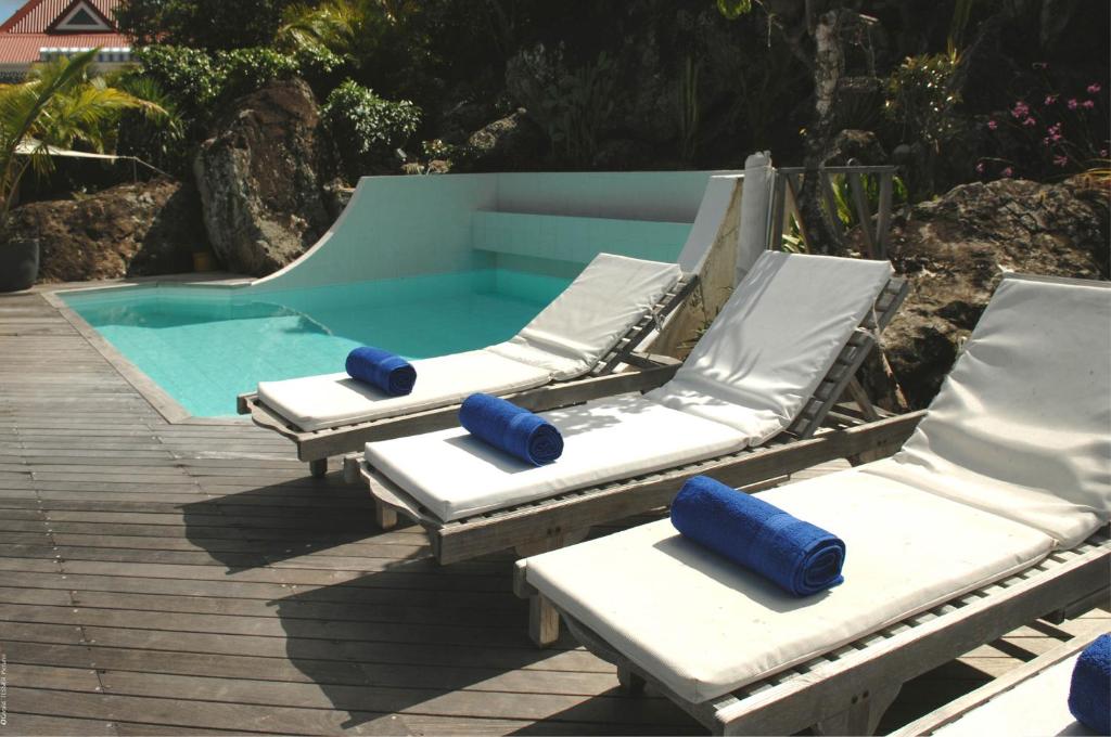 three chaise lounges and a swimming pool at Dream Villa Flamands 630 in Saint Barthelemy