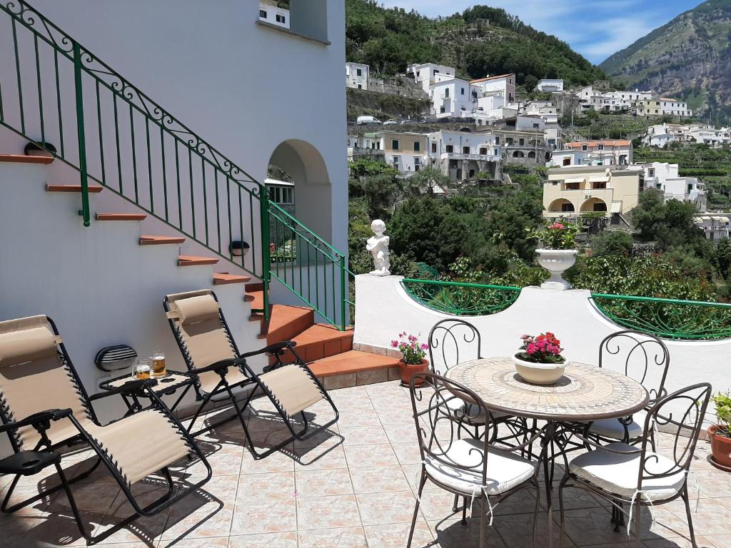een patio met een tafel en stoelen en uitzicht bij SILVY HOUSE in Amalfi