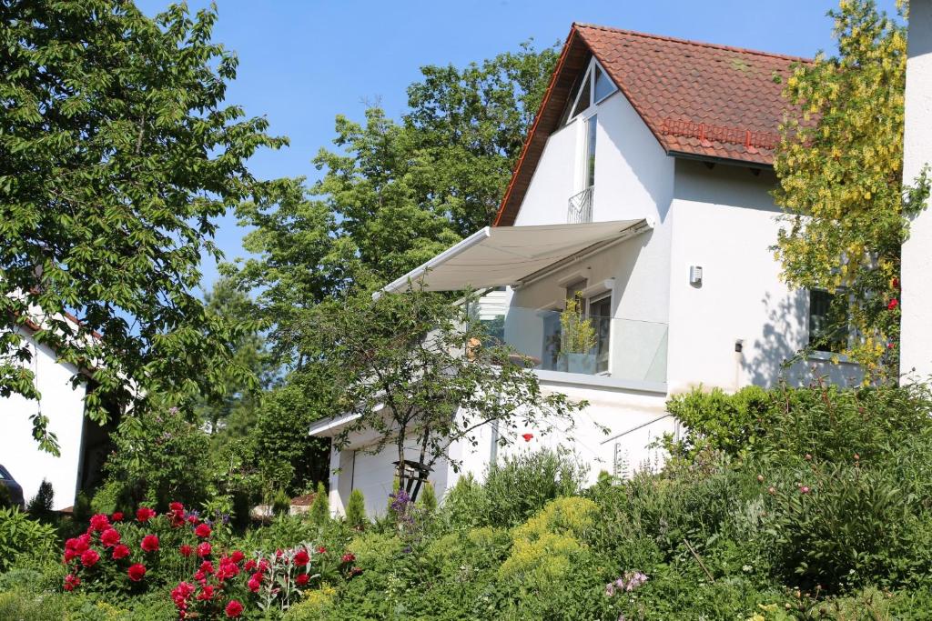 ein weißes Haus mit rotem Dach in der Unterkunft Ferienwohnung Brüssing in Pentling