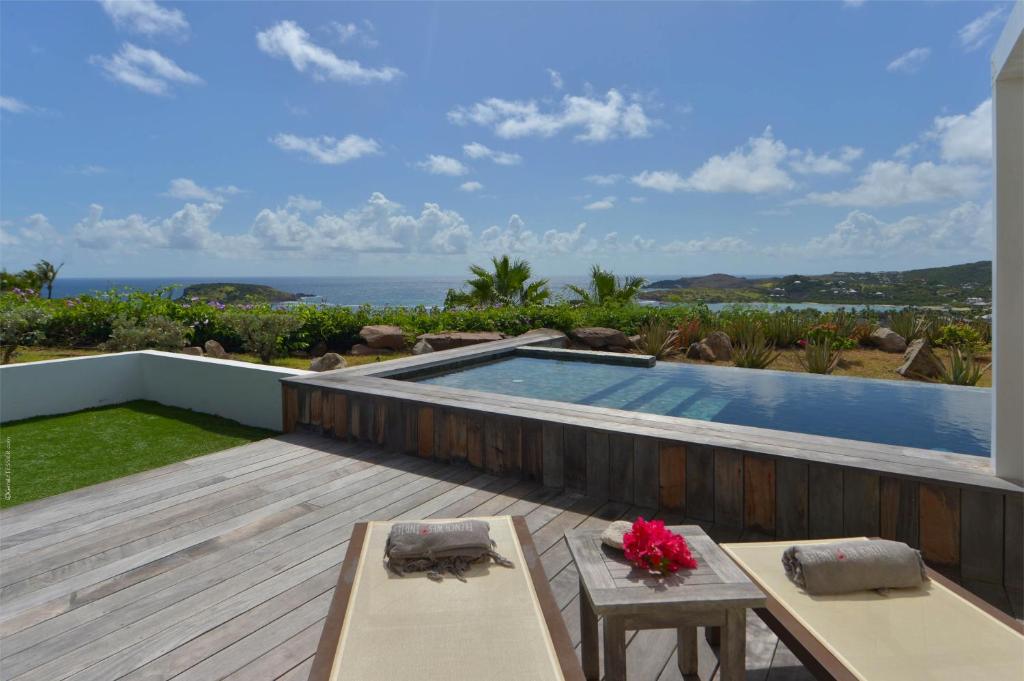 a backyard with a swimming pool and a wooden deck at Dream Villa Mont Jean 657 in Saint Barthelemy