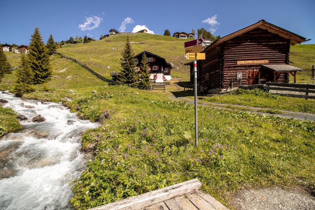 a small river next to a log cabin at Chalet Büdemji by Arosa Holiday in Arosa