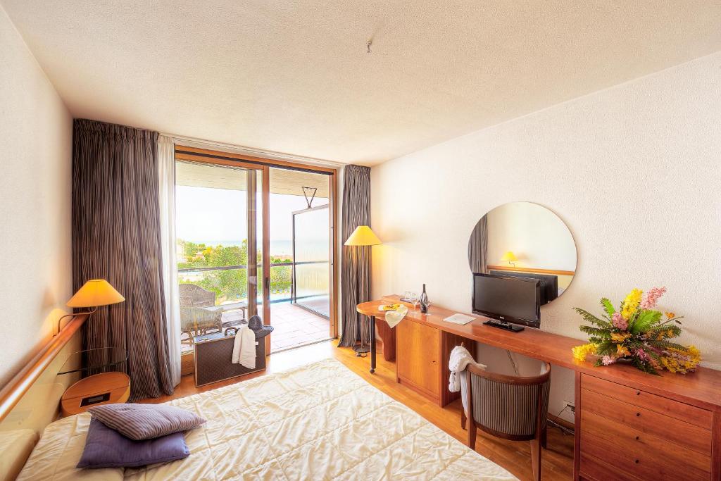 シルヴィ・マリーナにあるGrand Hotel Bertiのテレビ、鏡付きデスクが備わる客室です。