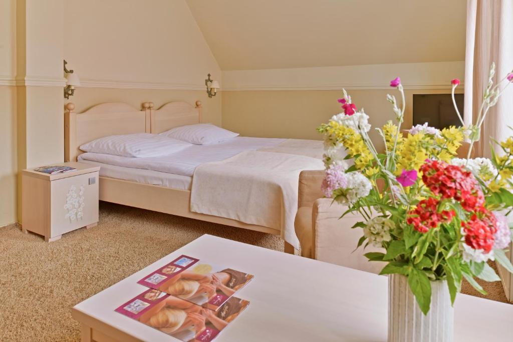 Cozy room with double bed, colorful flowers on table, and soft lighting.