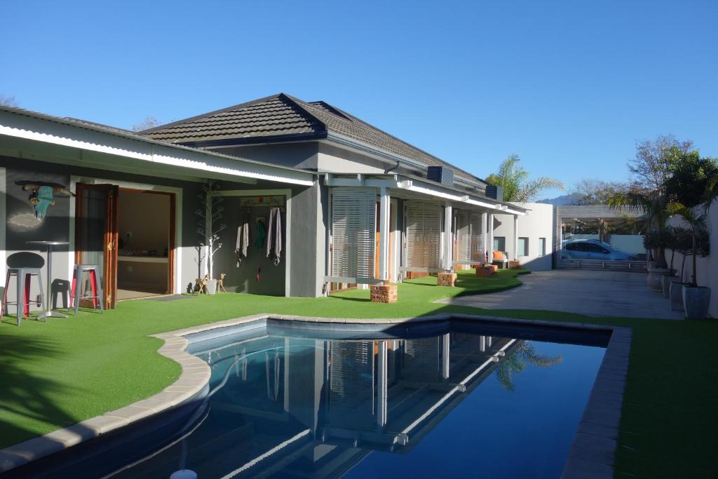 a house with a swimming pool in front of a house at Two Fat Owls Guesthouse in George