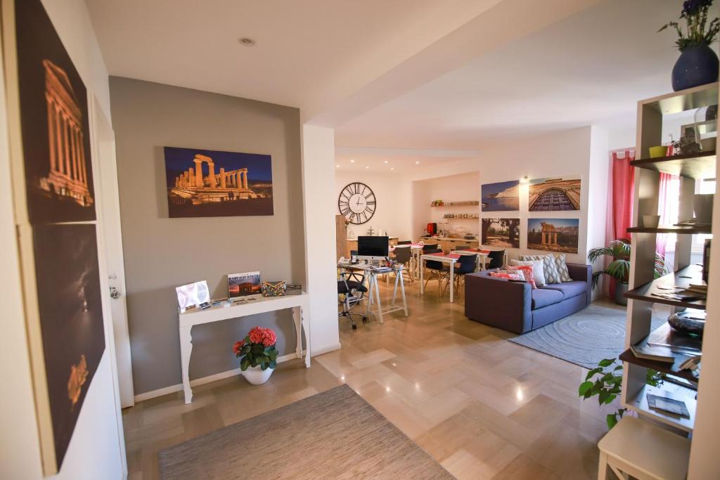 a living room and dining room with a clock on the wall at B&B Porta di Ponte in Agrigento