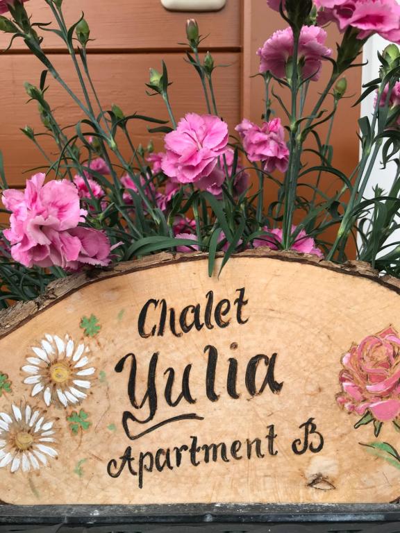 una señal para un jardín con flores rosas en Chalet Yulia, en Zell am See