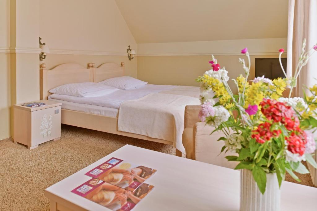 Cozy room with double bed, colorful flowers on table, and soft lighting.