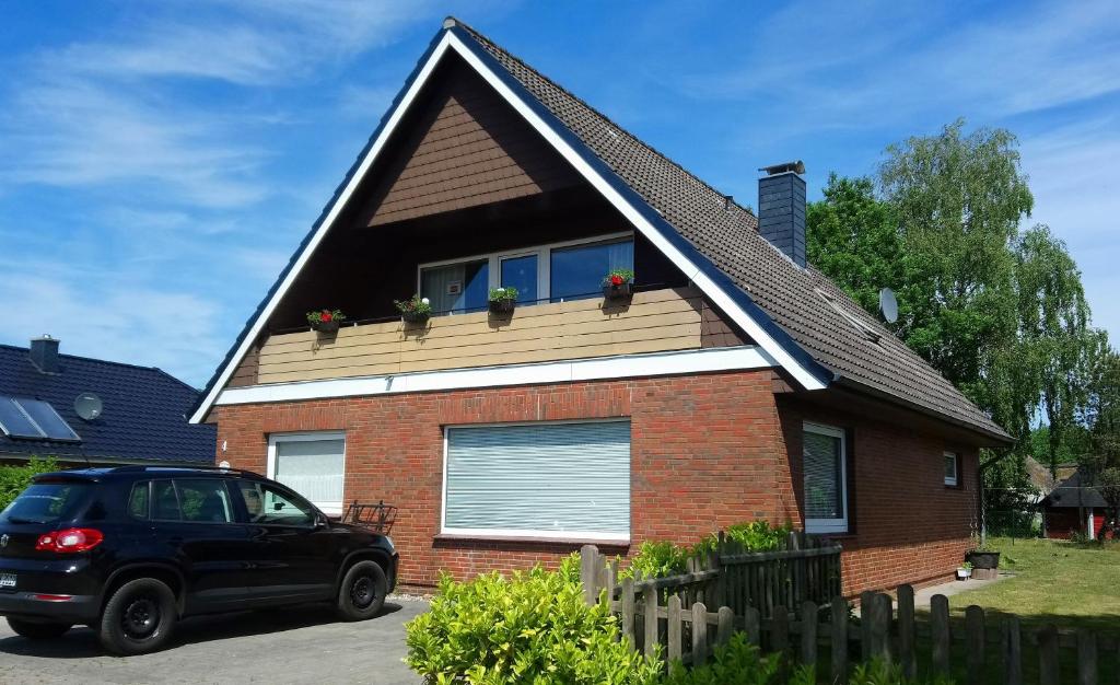 a black car parked in front of a house at Ferienwohnung Anna in Süderstapel