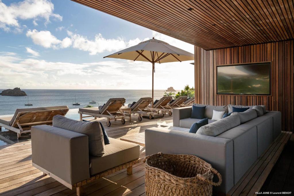 a living room with couches and chairs and the ocean at Dream Villa Corossol 776 in Saint Barthelemy