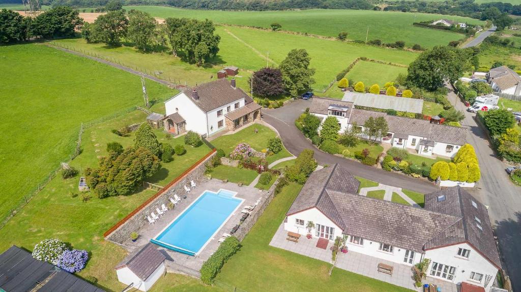 una vista aérea de una casa con piscina en Trenewydd Farm Holiday Cottages, en Cardigan