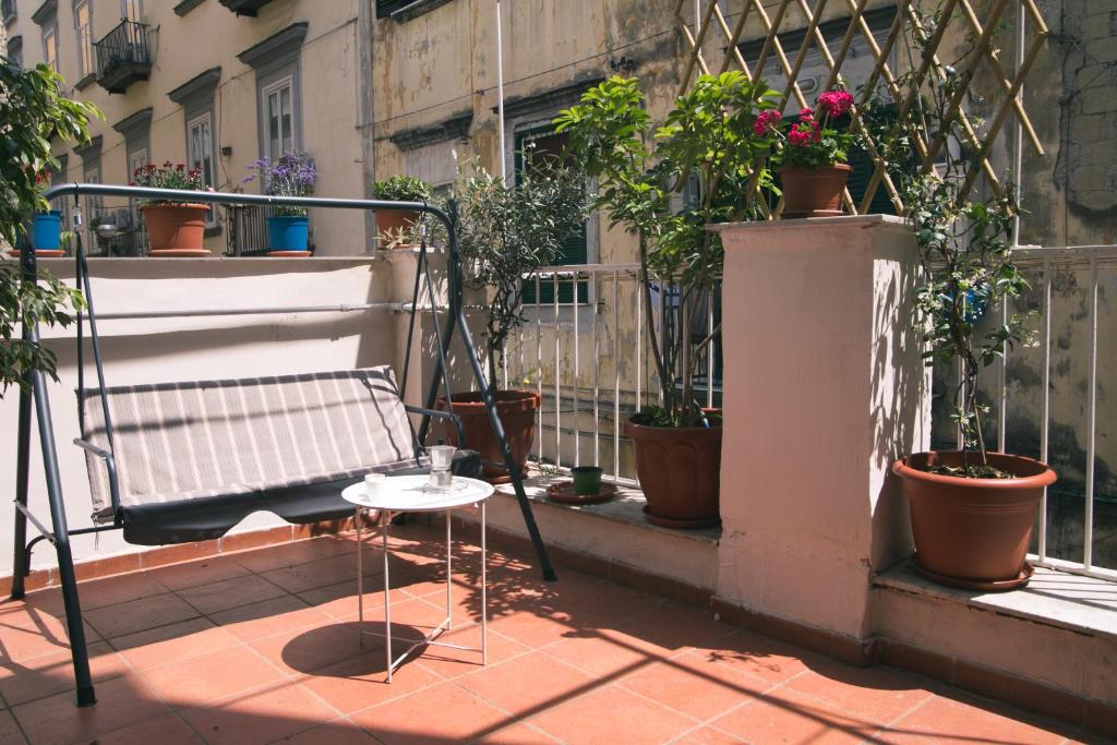 a balcony with a bench and potted plants at La casa del Nespolo in Naples