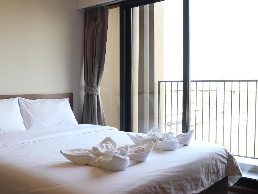 uma cama com três tigelas brancas com uma janela em Rangsit Residence em Ban Talat Rangsit