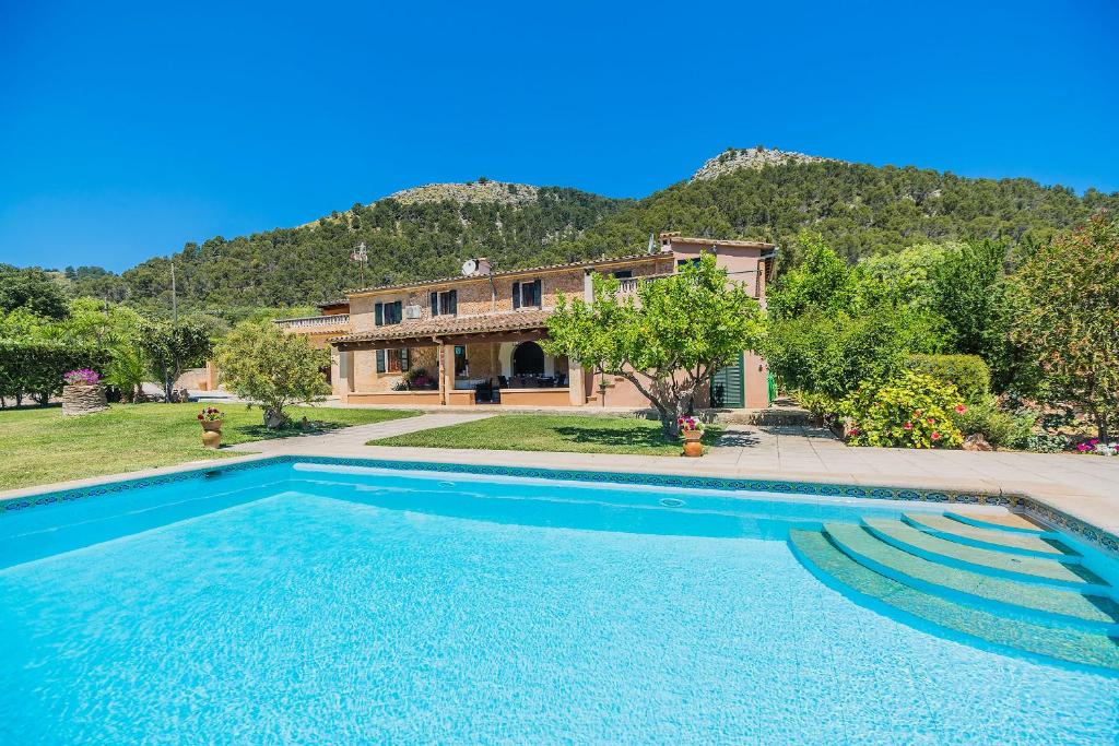 a large swimming pool in front of a house at Can De L'ausina in Pollença