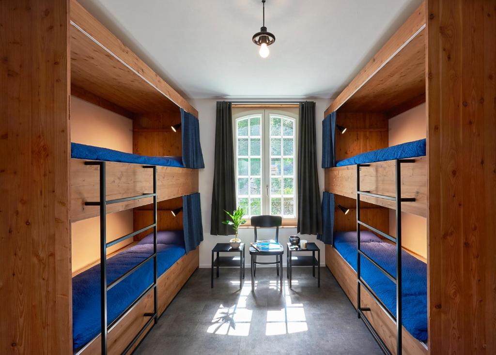 a room with bunk beds and a table in it at Chalet Turbina in Zermatt