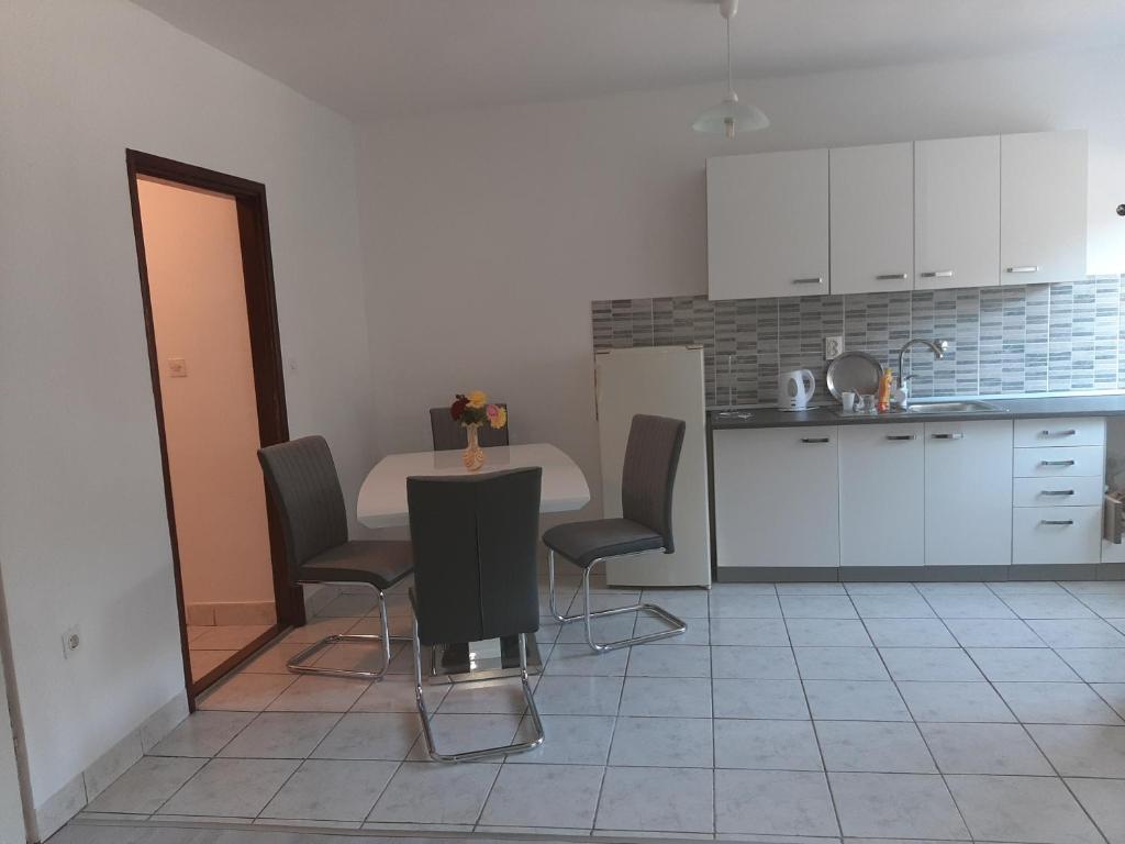uma cozinha com mesa e cadeiras num quarto em Apartman Čurčić em Knin