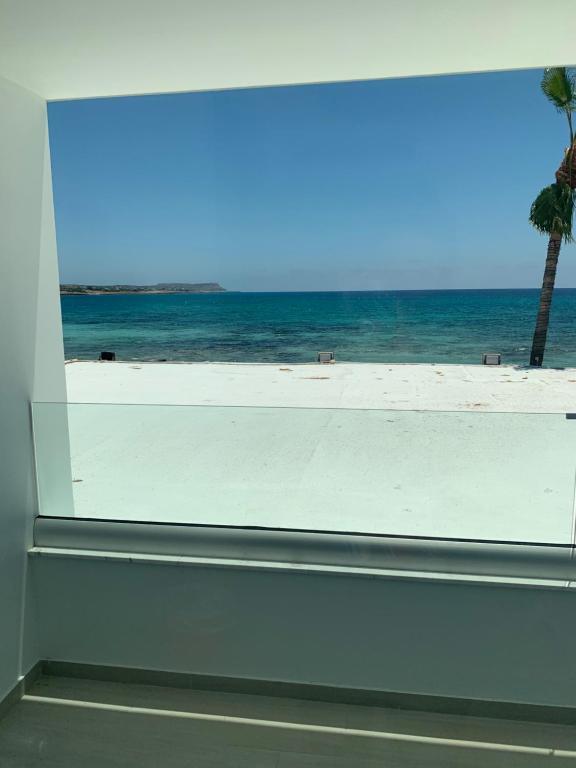 a view of the beach from a window at Karousos Beach Rooms in Ayia Napa