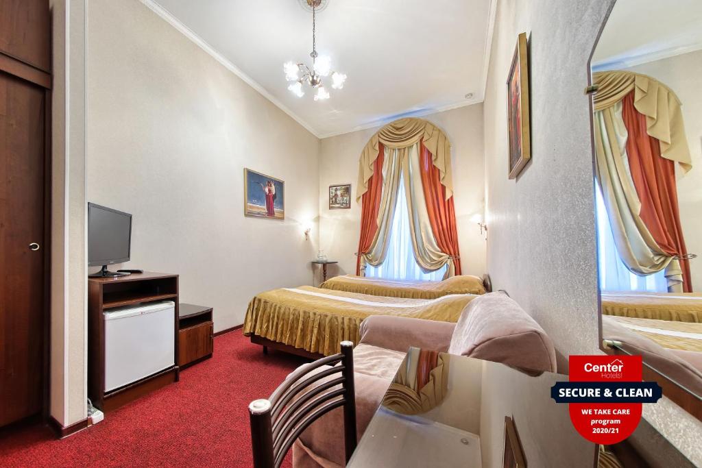una camera d'albergo con due letti e una televisione di Antares on Nevsky Prospect a San Pietroburgo