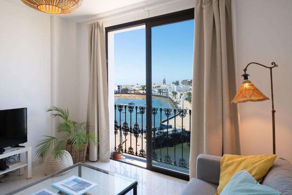 a living room with a view of a balcony at Living El Charco, piso individual in Arrecife