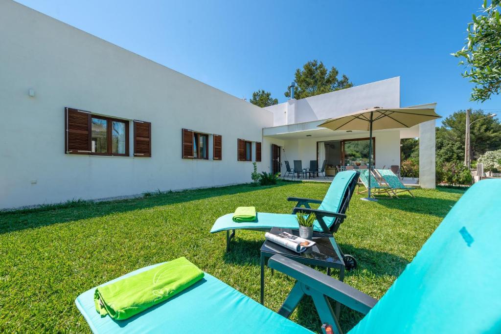 a backyard with a table and chairs and a house at Amedart in Alcudia