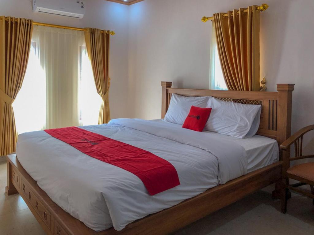 a bedroom with a bed with a red pillow on it at RedDoorz near XT Square 3 in Yogyakarta