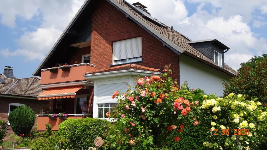 een huis met een bloeiende struik ervoor bij FEWO Am Kiesteich im Weserbergland in Rinteln