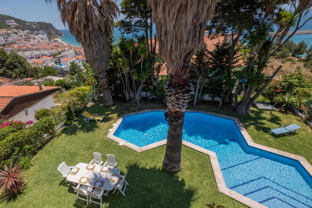 an image of a villa with a pool and a table and chairs at Rent4rest Sesimbra 4Bdr Ocean View and Private Pool Villa in Sesimbra