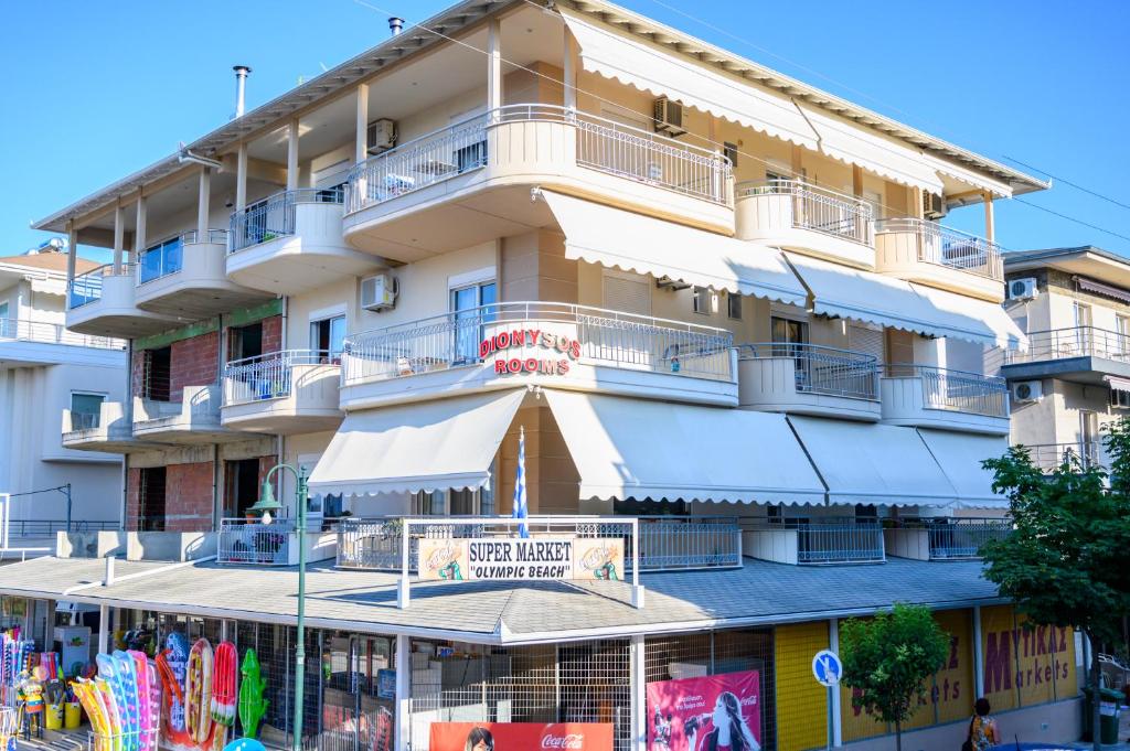 ein hohes Gebäude mit weißen Markierungen davor in der Unterkunft Dionysos Rooms in Olympiakí Aktí