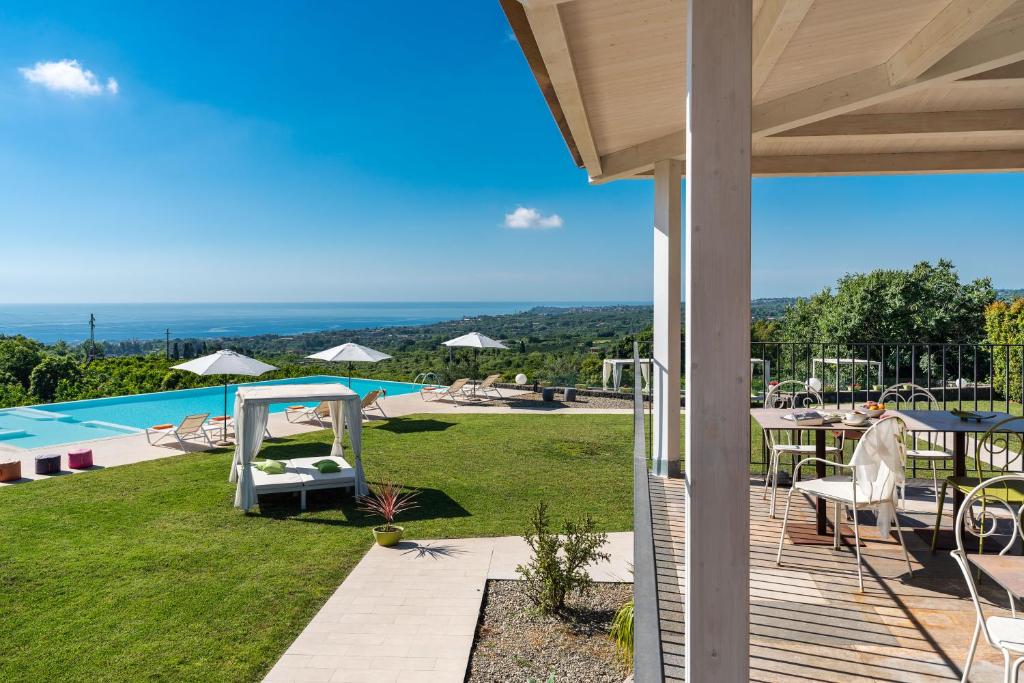聖韋內里納的住宿－卡珀斯埃特納瑞雷斯私享Spa酒店，从带游泳池的房屋的庭院中欣赏美景