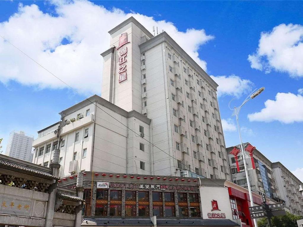 a tall white building on a city street at Jinjiang Inn - Changsha Wuyi Square in Changsha
