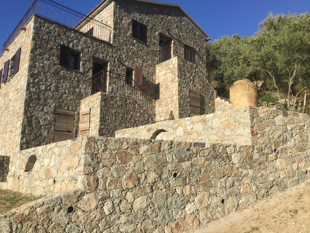 a building on top of a stone wall at Résidence Casa Di Roc in Urtaca