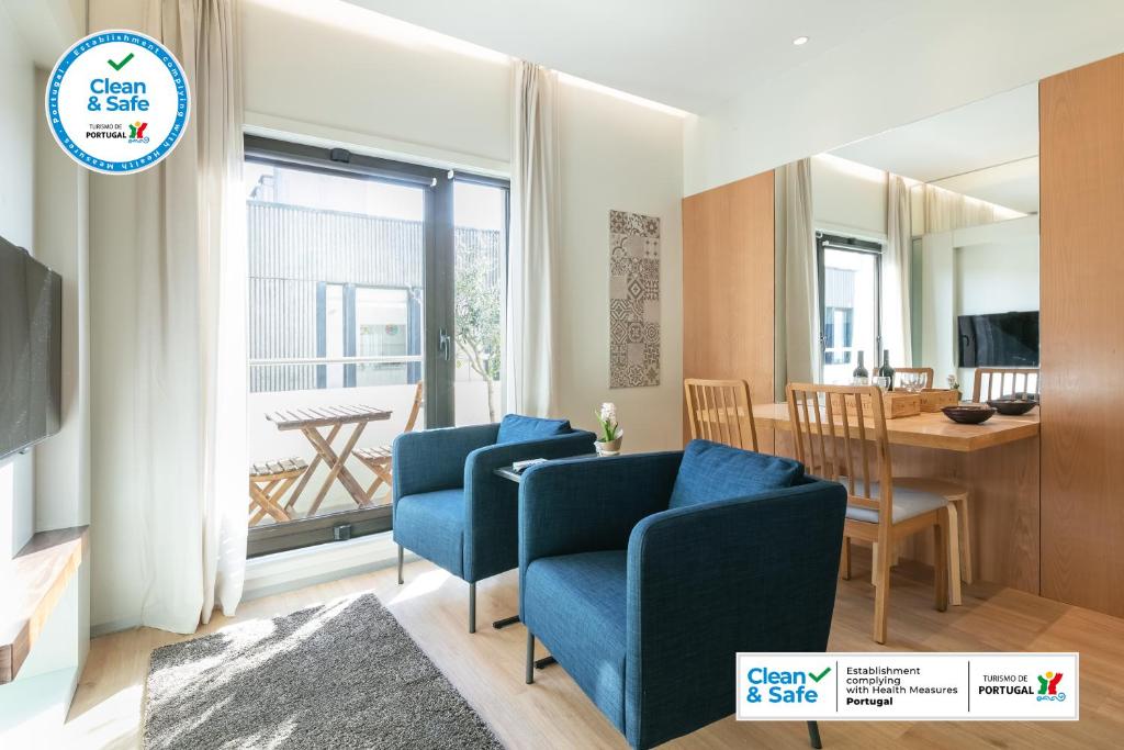 uma sala de estar com duas cadeiras azuis e uma mesa em Inn Oporto Downtown New Apartments no Porto