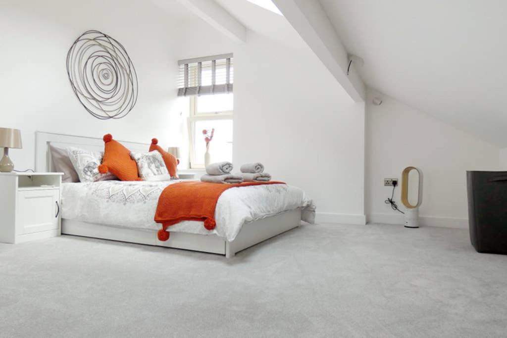 a white bedroom with a bed with orange pillows at Copley Loft 3 Bedroom House with Patio in Shepley