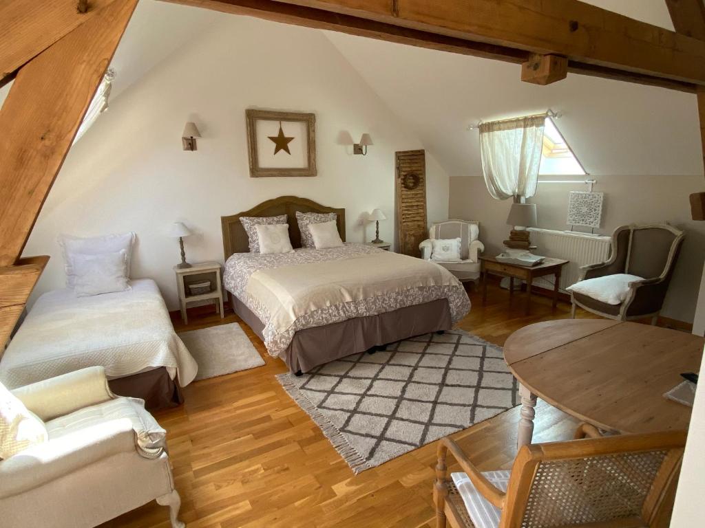 a attic bedroom with two beds and a table at La Suite du 12 in Brie