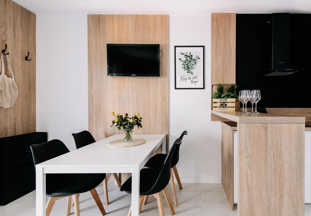 a dining room with a white table and black chairs at SeaSide Apartment in Rowy