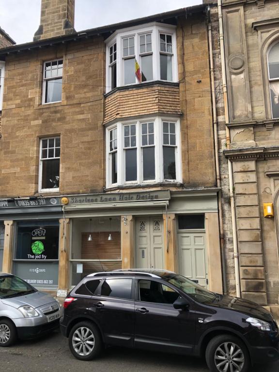 un todoterreno negro estacionado frente a un edificio en Castle Gate Apartment, en Jedburgh