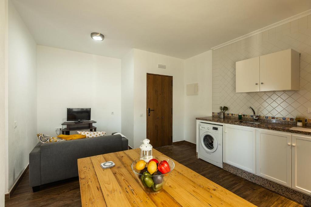 a kitchen and a living room with a table with fruit on it at APARTAMENTO BOLONIA SUR A in Bolonia