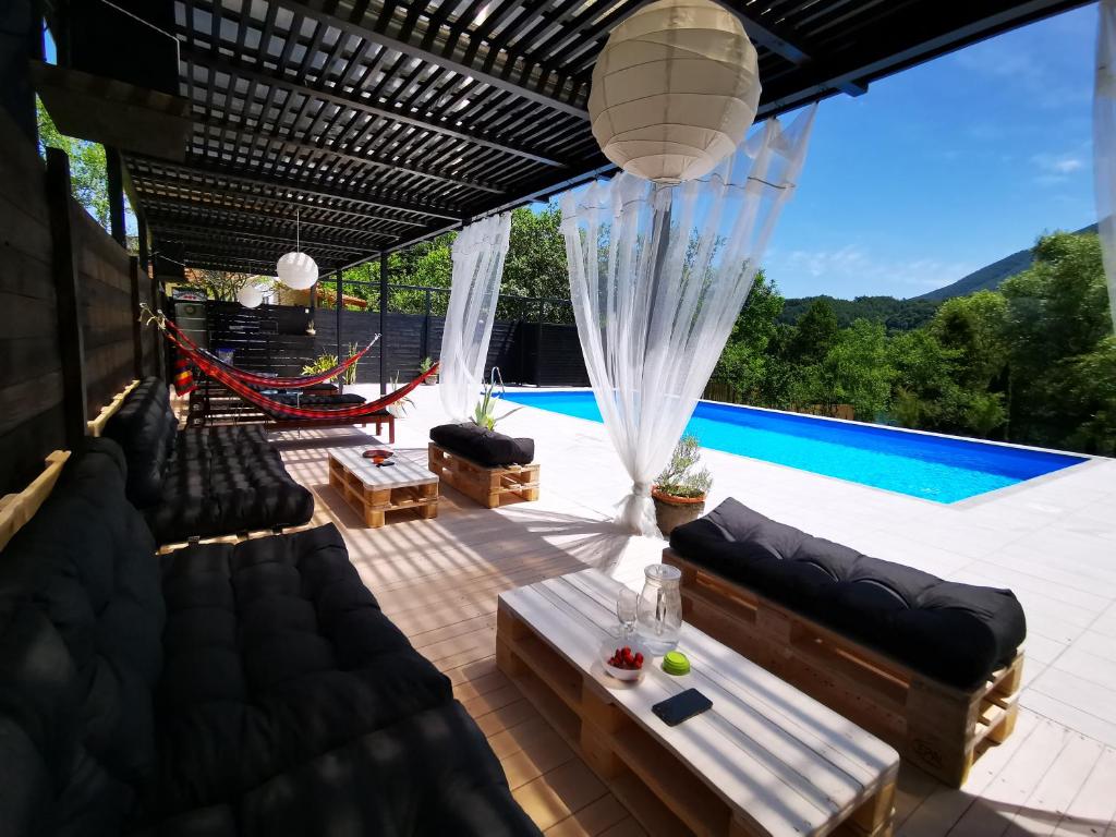 un patio con sofá y piscina en Mila Holiday Home, en Lohovo