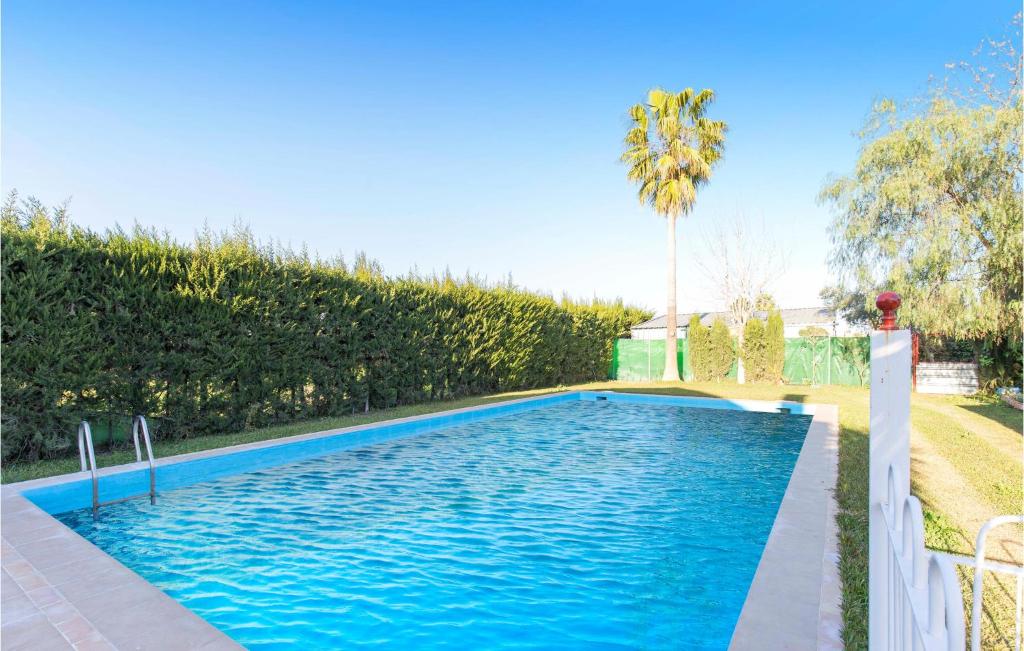 洛斯帕拉西奧西維利亞夫蘭卡的住宿－Lovely Home In Los Palacios With Private Swimming Pool, Can Be Inside Or Outside，庭院里的一个蓝色海水游泳池