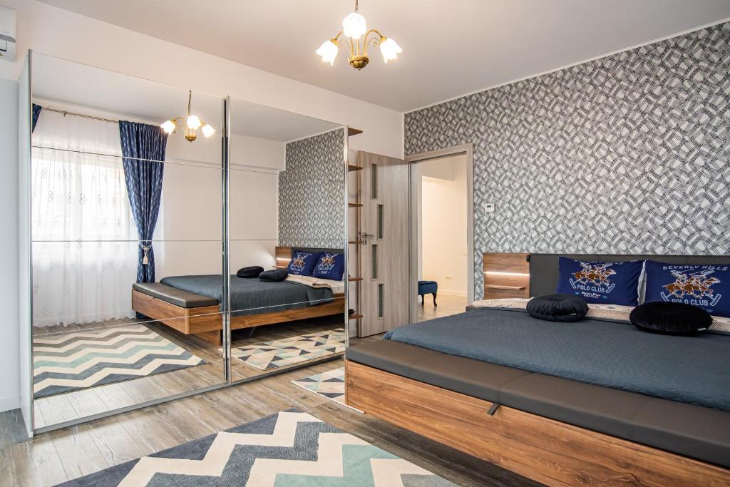 1 dormitorio con 2 camas y espejo en Blue Boutique Magic View of the Sea Apartments, en Mamaia