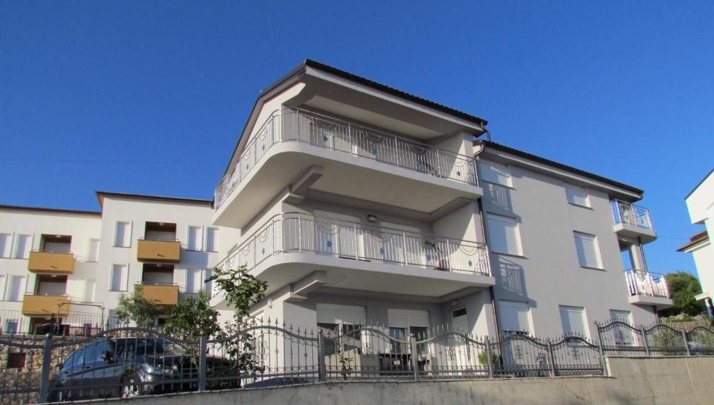 an apartment building with balconies and a car parked in front at Apartment Delic in Crikvenica