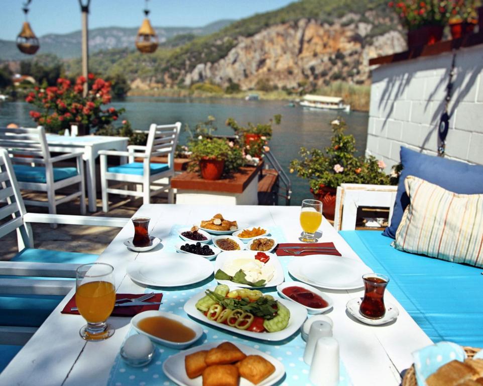 a table with plates of food and drinks on it at Myra Hotel in Dalyan