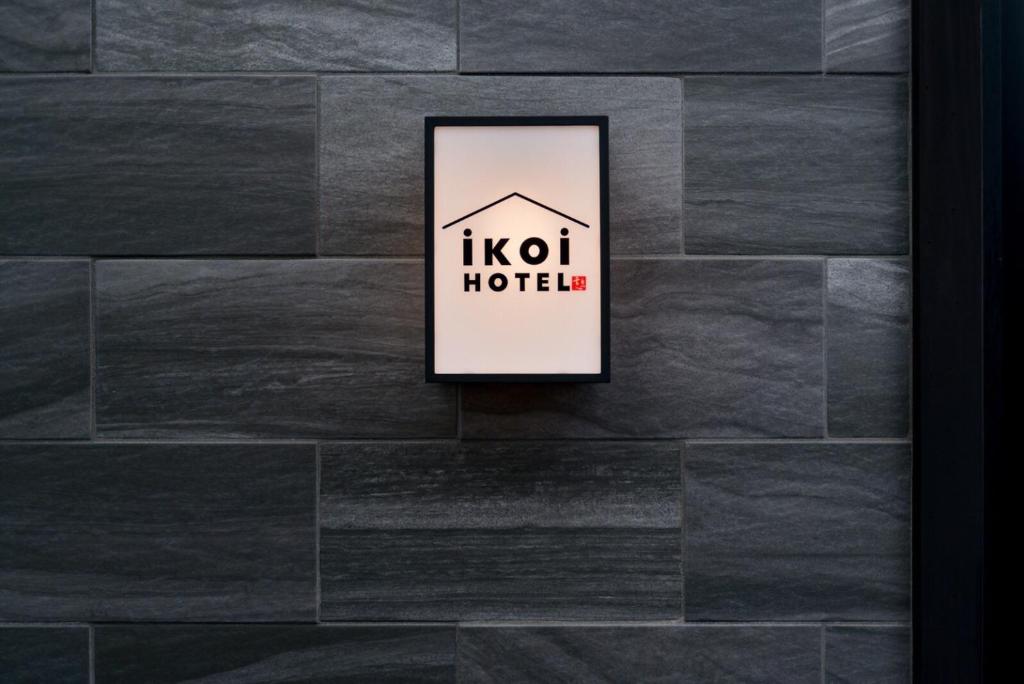 京都的住宿－ikoi HOTEL，石墙上的酒店标志