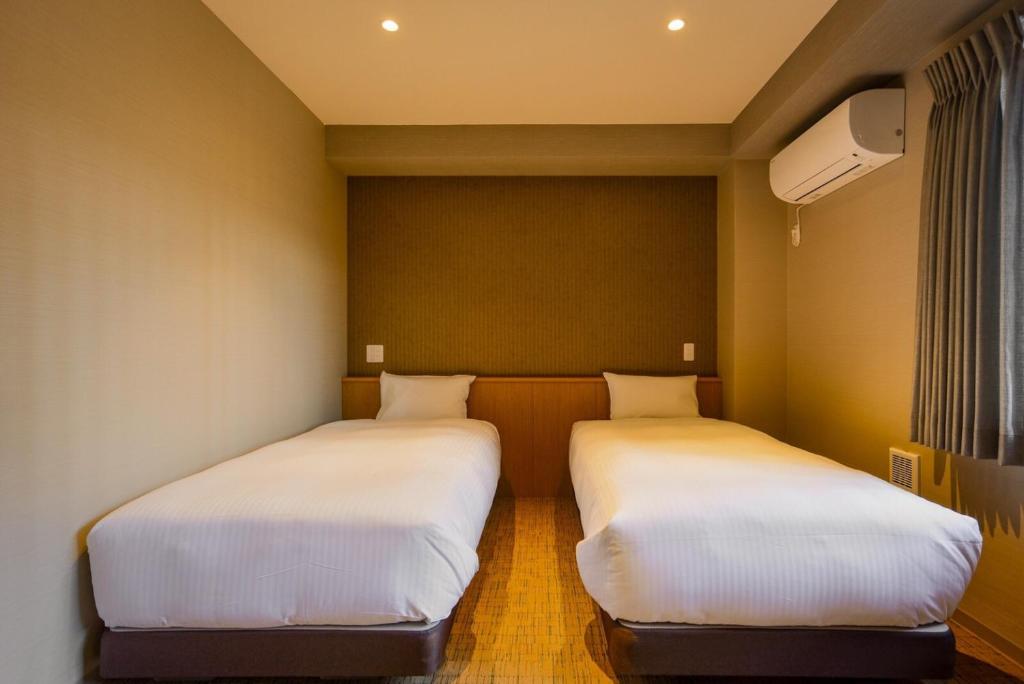 Postel nebo postele na pokoji v ubytování ikoi HOTEL